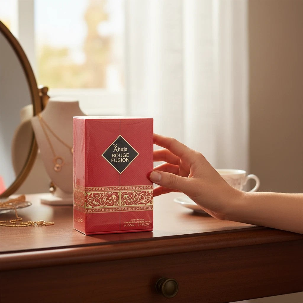 Noticed Atelier by Legzdiamond Ahuja Rouge Fusion Eau de Parfum box on a vanity table with a hand reaching for it.