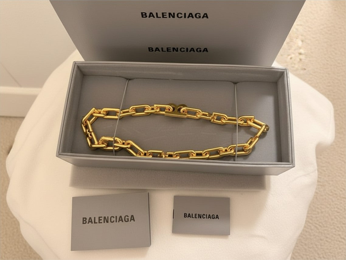 Noticed Atelier by Legzdiamond Balenciaga gold chain choker in a grey branded presentation box with authenticity tags