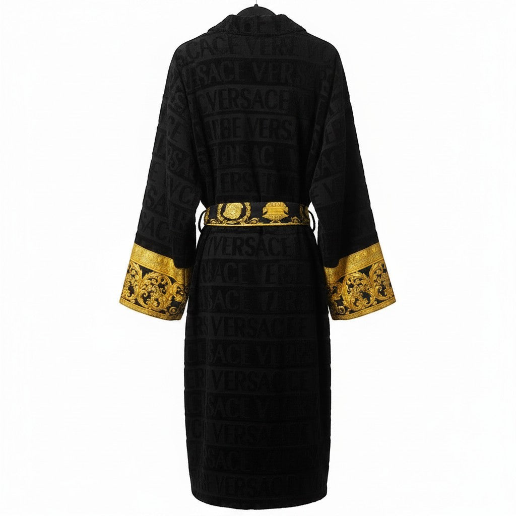 Noticed Atelier by Legzdiamond black plush cotton bathrobe with embossed logo pattern and gold Baroque print cuffs.