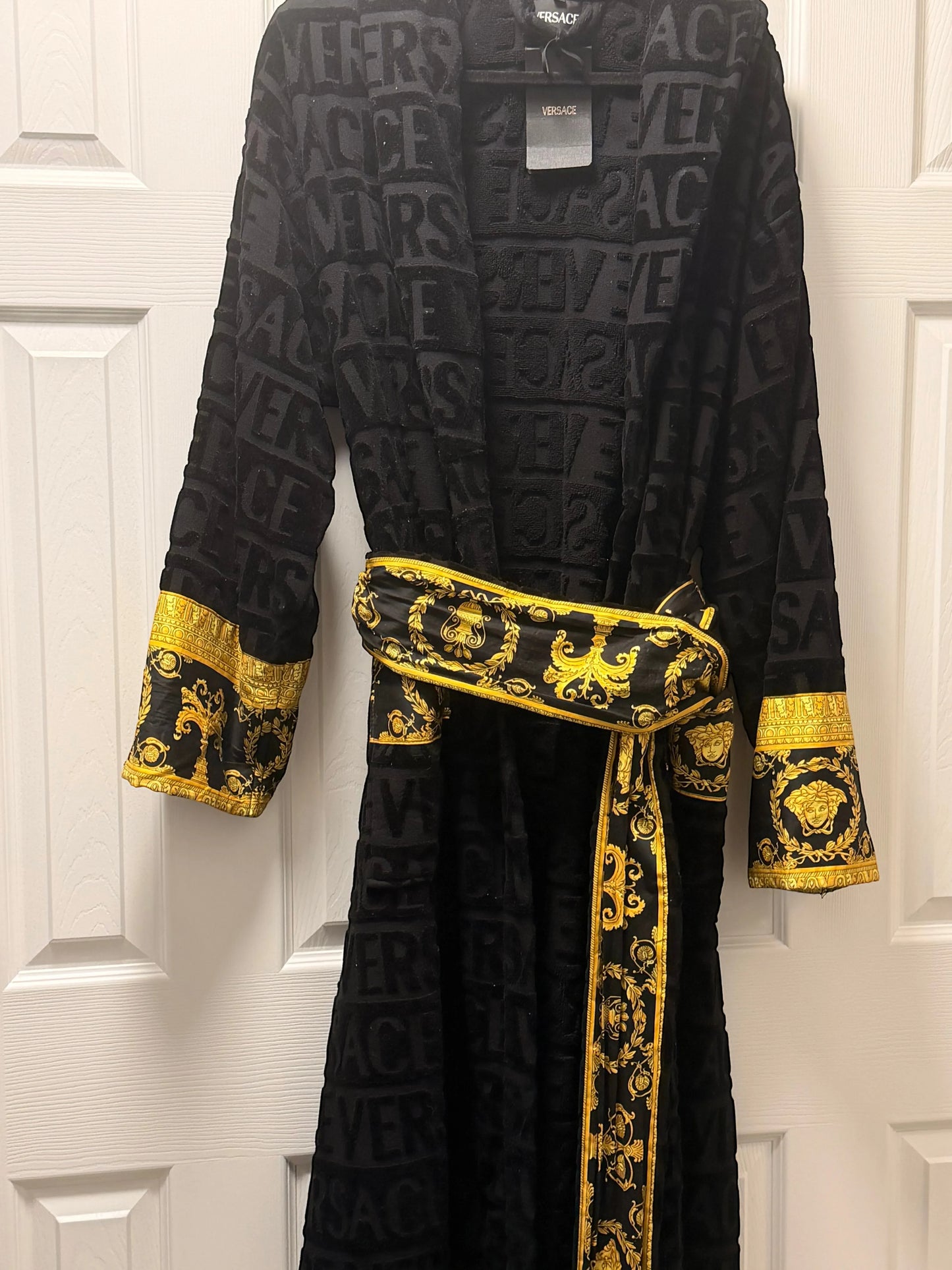 Noticed Atelier by Legzdiamond black plush cotton bathrobe with embossed logo pattern and gold Baroque print cuffs