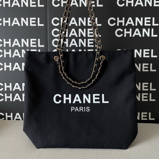 Noticed Atelier by Legzdiamond black canvas Chanel Paris tote bag with signature gold chain and leather straps