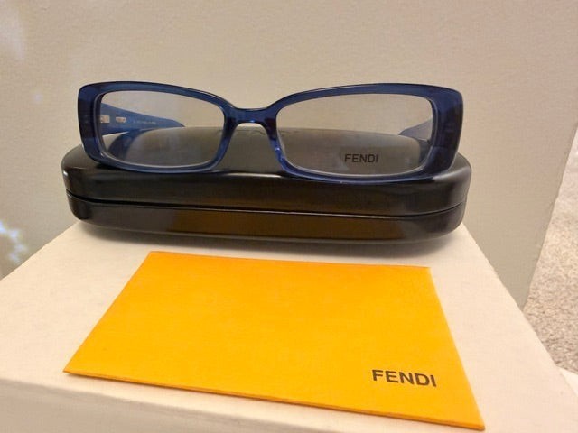 Noticed Atelier by Legzdiamond Fendi sunglasses with petite blue frames and clear lenses, displayed with case and card.