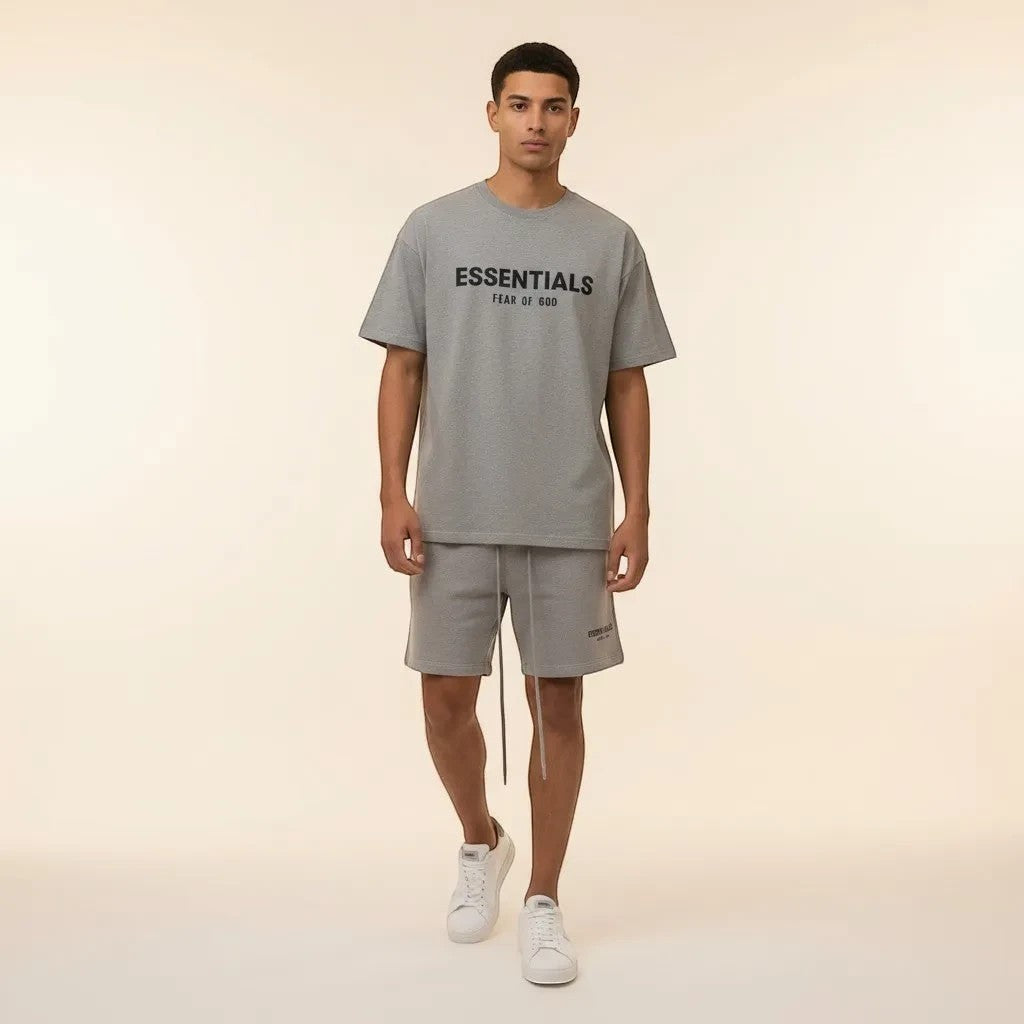 Model wearing Noticed Atelier by Legzdiamond heather grey Essentials Fear Of God cotton t-shirt and shorts set.