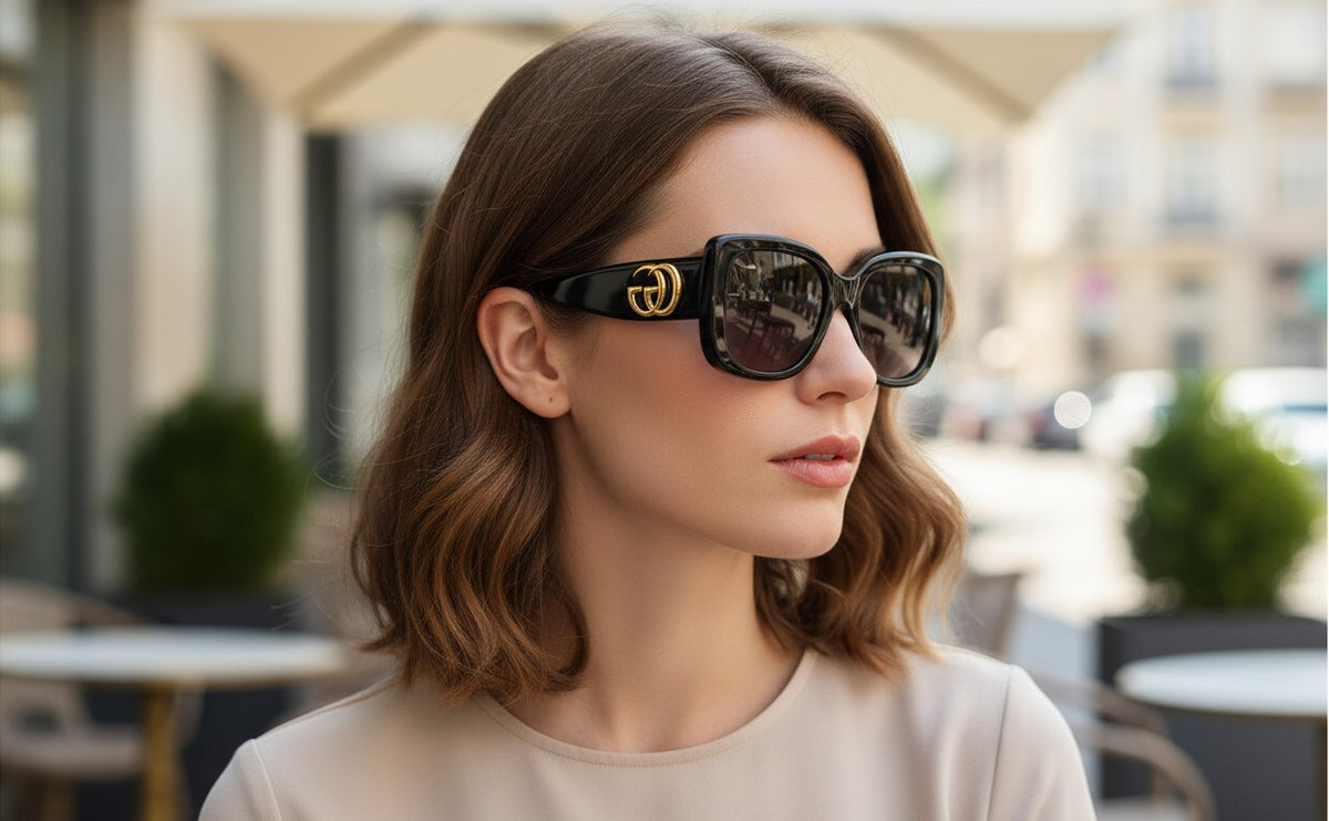 Woman wearing Noticed Atelier by Legzdiamond Gucci GG logo black frames with rose gold tinted lenses outdoors
