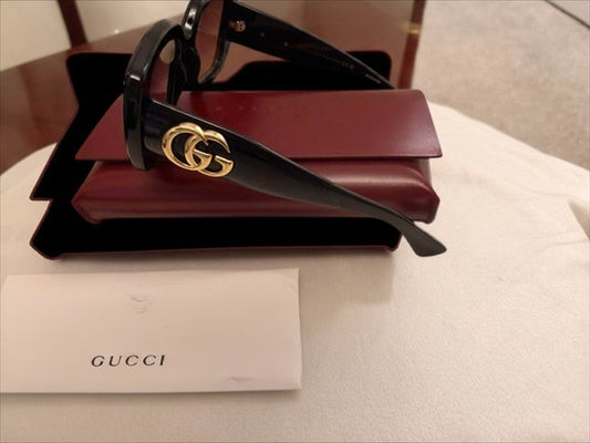 Noticed Atelier by Legzdiamond Gucci black frames with gold GG logo hardware and rose gold tinted lenses in a case