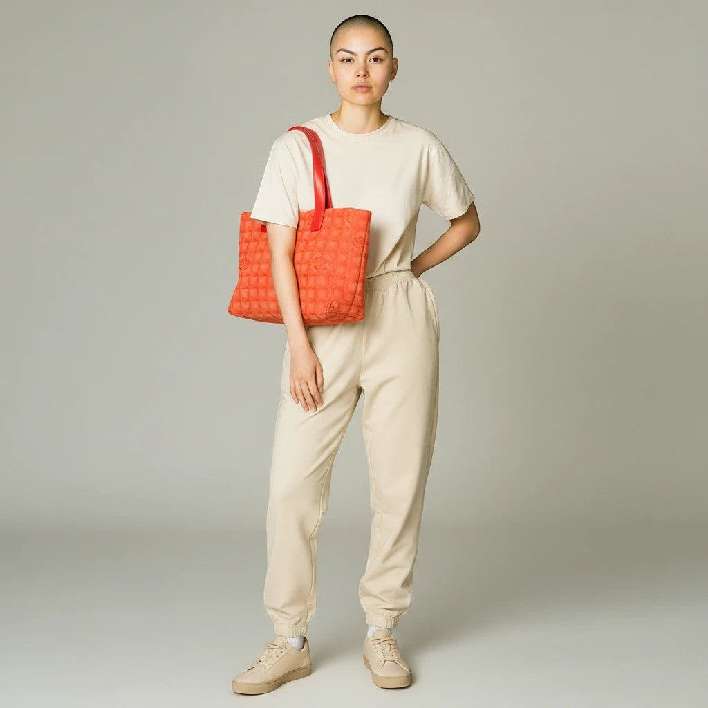 Model wearing Noticed Atelier by Legzdiamond vintage Chanel tote in pink and coral with a structured quilted design