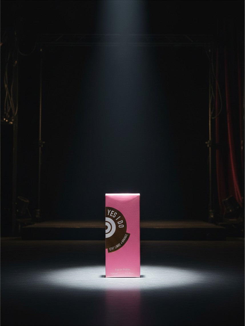 Noticed Atelier by Legzdiamond Etat Libre d'Orange Yes I Do Eau de Parfum in a vibrant pink box under a spotlight.
